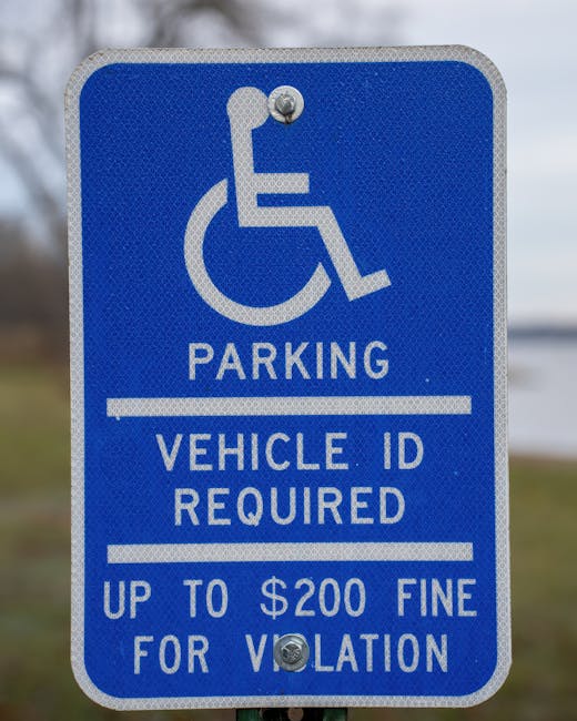 A black sports car with sleek design and large alloy wheels is parked adjacent to a designated accessible parking space marked with a white wheelchair symbol painted directly on the asphalt surface. T